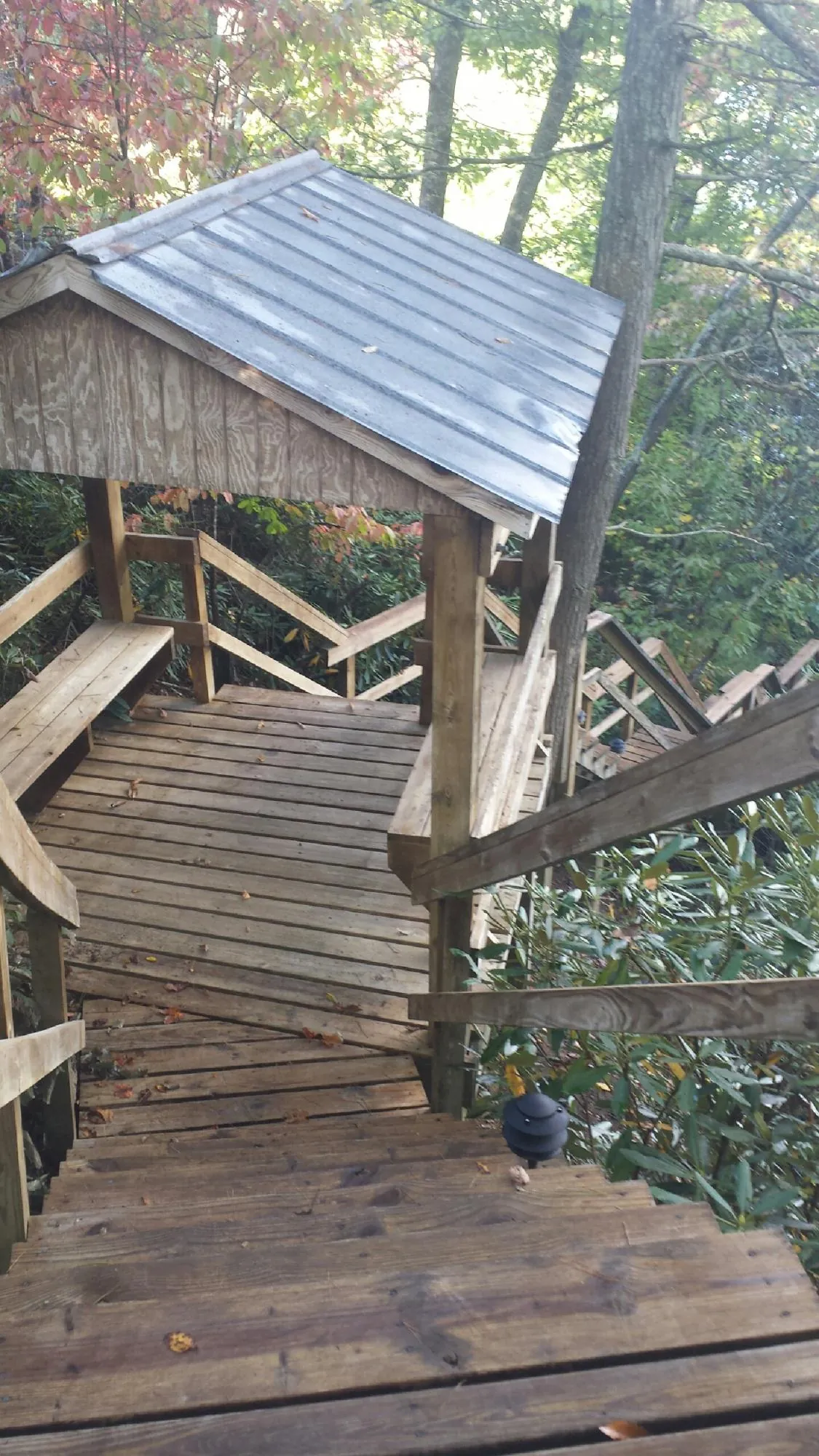 Metal roofed shelter over wooden steps on a wooded walkway — Skylight Repair & Installation work by our crew in Bridgeport